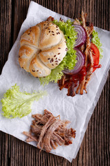 Pulled pork burger with coleslaw tomato, onion and fresh bread.