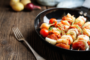 Vegetable and meat on wooden skewers on plate