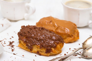 eclairs on white dish on wooden background