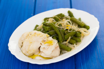 boiled fish with green beans on white dish