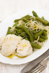 boiled fish with green beans on white dish