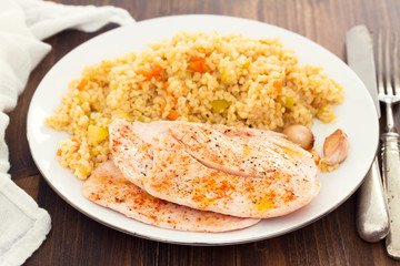 grilled chicken breast with couscous on white dish
