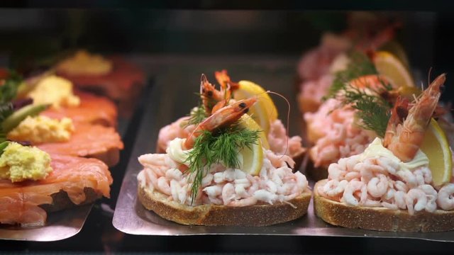 Denmark, scandinavian open sandwich. Delicious rye bread with different kind of meat, seafood, vegetable topping shot in slow motion 
