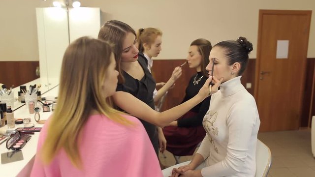 Make-up artist conducts training lesson of the technique of makeup.