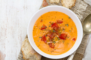 tomato soup in white bowl on wooden background
