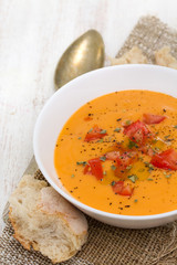 tomato soup in white bowl on wooden background