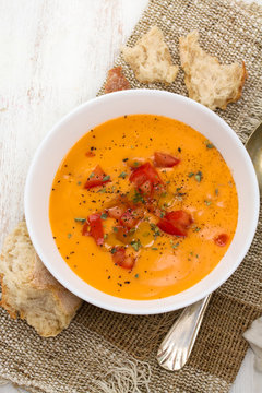 tomato soup in white bowl on wooden background