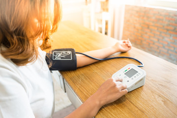Woman measures her blood pressure.