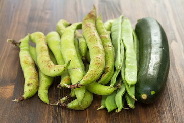 green fresh vegetables on brown wooden background