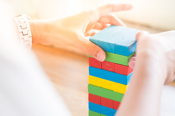 Close-up of asian business man's hand playing wood blocks stack game