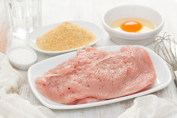 raw turkey, dry bread and egg on wooden background