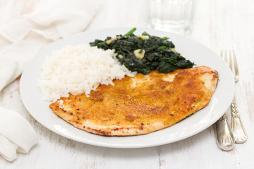 fried turkey with rice and spinach on the dish