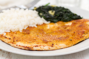 fried turkey with rice and spinach on the dish