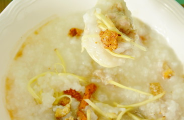 boiled rice with minced pork and slice ginger on plastic soup spoon