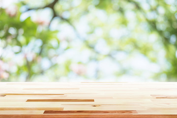 Empty wooden table with party in garden background blurred.
