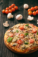 Homemade pizza with ham,mushrooms, tomatoes and cheese.