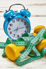 Dumbbells, tape and alarm clock. Intrduction to weight loss.