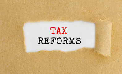 Text Tax Reforms appearing behind ripped brown paper.