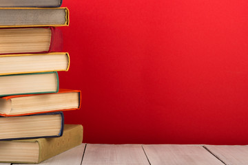 education and wisdom concept - books on wooden table, color background