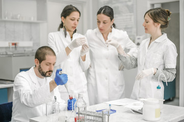 Group of scientists working with liquid test tube samples