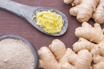 Powdered roots and ginger grated on wooden background