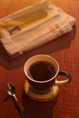 cup of coffee with Newspaper on wooden