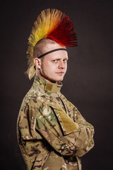 punk rocker in military camouflage uniform with arms crossed. Military , lifestyle,  people concept