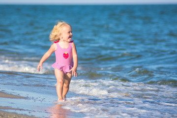 Fototapeta na wymiar Smiling girl walks by the water