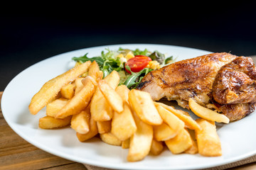 Chicken skewers with sauce and golden French fries potatoes