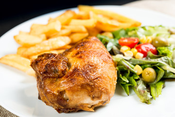 Chicken skewers with sauce and golden French fries potatoes