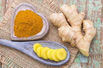 Powdered roots and ginger grated on wooden background