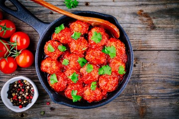 Meatballs with tomato sauce and parsley in cast iron pan