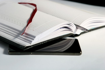 The open book lies on the desk with the phone