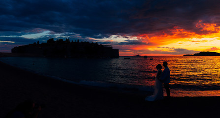 Silhouettes of couples near Sveti Stefan island in Montenegro