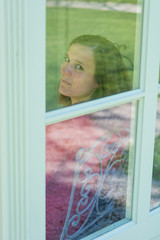 Attractive brunette looking through a window.