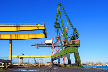 Yellow gantry cranes and green crane in the port of Gdansk. Poland.