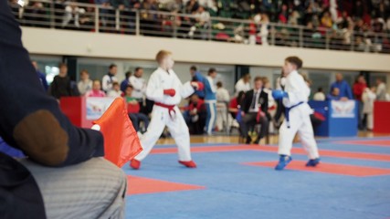Martial art competitions- karate - judge coaches looking at female teenager's karate fighting © KONSTANTIN SHISHKIN