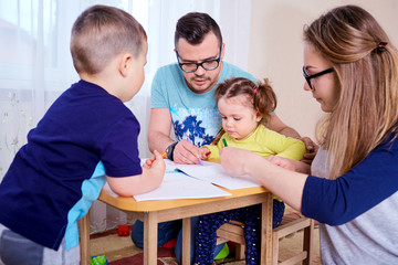 Obraz premium Parents and children draw together in the room.