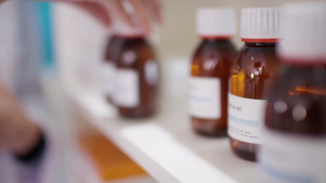  Unrecognizable worker in a herbal medicine pharmacy checking stock