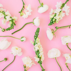 Floral pattern made of white flowers - ranunculus, snapdragon and tulip on pink background. Flat lay, top view.