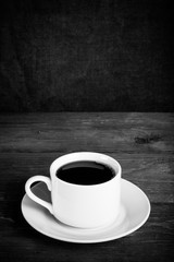 White cup of tea on old wooden table against the background of burlap. Selective focus. Shallow depth of field. Toned
