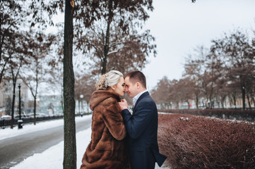 Couple in love gently hugging outdoors in winter.