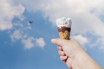 Ice cream cone held up to the hot summer sky