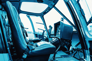 Helicopter cab interior, side view of the seat and the dashboard. Heli on the ground.