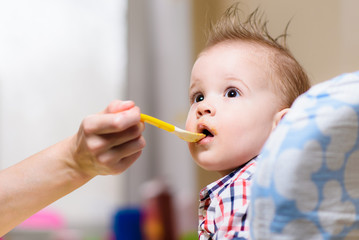 mother feeding her baby breast porridge day