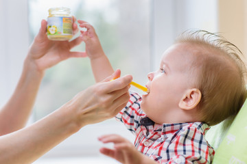 mother feeding her baby breast porridge day