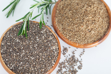  Grained and grinded chia seed in wooden bowls. Healthy eating, vegan diet concept.