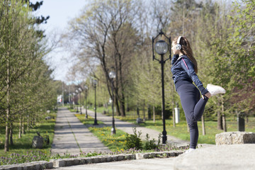 Young pretty girl doing exercise and running in the park