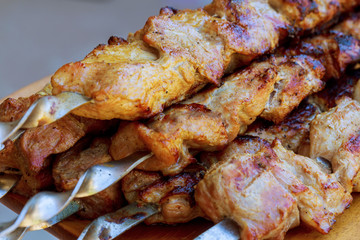 Grilled kebab cooking on metal skewer closeup. Roasted meat cooked at barbecue.