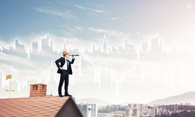 Engineer man standing on roof and looking in spyglass. Mixed med